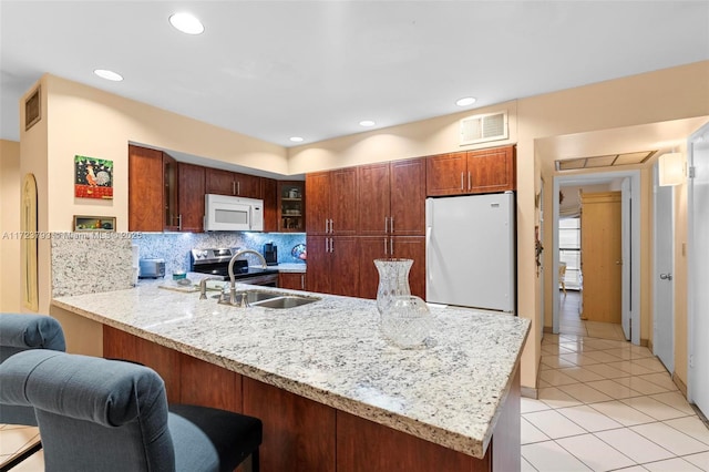 kitchen featuring kitchen peninsula, tasteful backsplash, white appliances, sink, and light tile patterned flooring