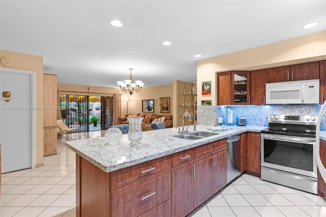 kitchen with an inviting chandelier, sink, light tile patterned floors, appliances with stainless steel finishes, and kitchen peninsula