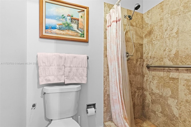 bathroom featuring a shower with shower curtain and toilet