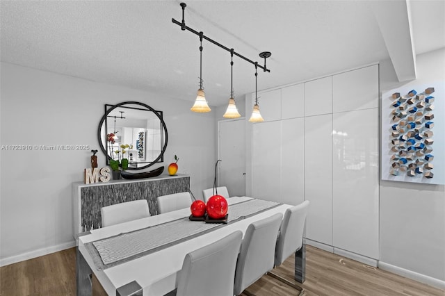 dining room with a textured ceiling and hardwood / wood-style flooring