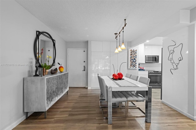 dining space featuring hardwood / wood-style flooring and a textured ceiling