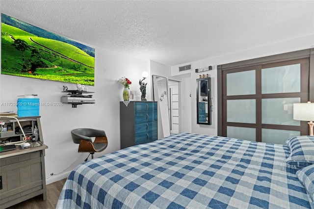 bedroom featuring wood-type flooring and a textured ceiling