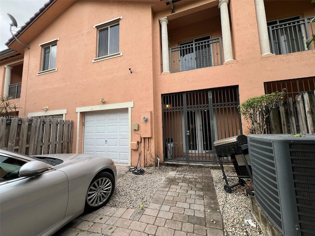 back of property featuring central AC and a garage