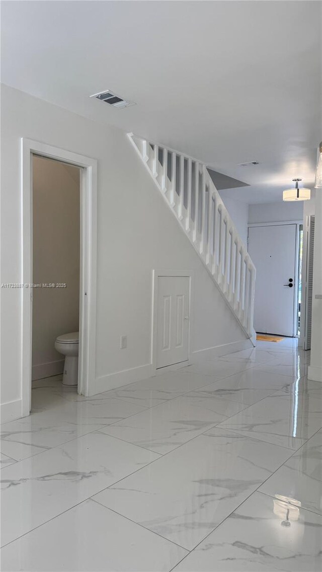 6850 NW 173rd Dr Unit 103, Hialeah, FL 33015 - unfurnished living room featuring stairs and light marble finish floors