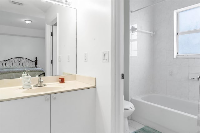 full bathroom featuring tiled shower / bath, tile patterned flooring, vanity, and toilet