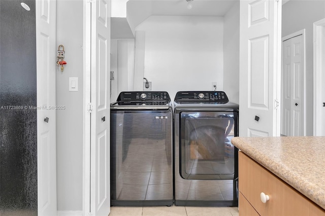 laundry area with light tile patterned flooring and washer and dryer