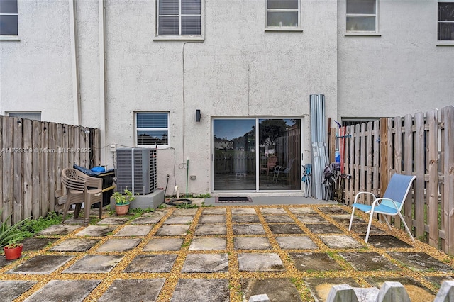 rear view of house with a patio area and central AC