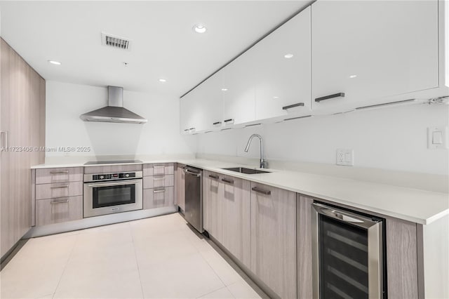 kitchen with appliances with stainless steel finishes, wall chimney exhaust hood, beverage cooler, sink, and light tile patterned floors