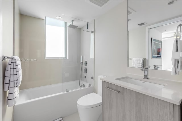 full bathroom featuring vanity, toilet, and shower / bath combination with glass door