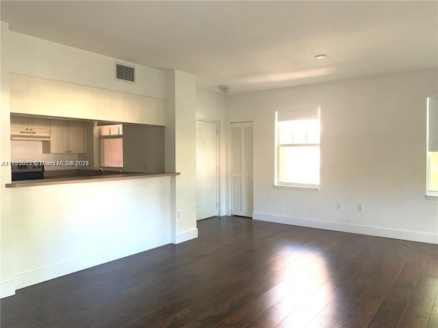 unfurnished living room with dark hardwood / wood-style flooring