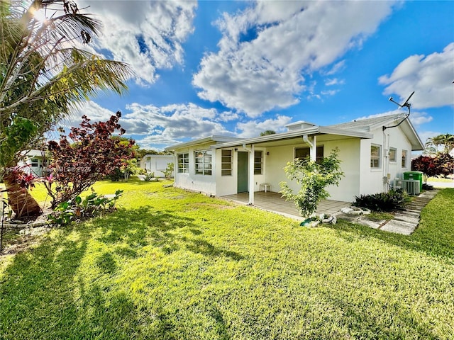 back of house featuring a lawn, a patio, and central AC