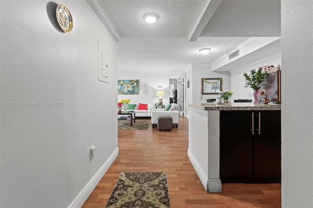 corridor with crown molding and hardwood / wood-style floors