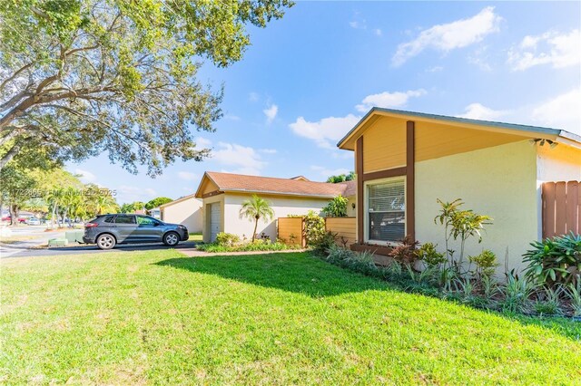 single story home with a front yard and a garage