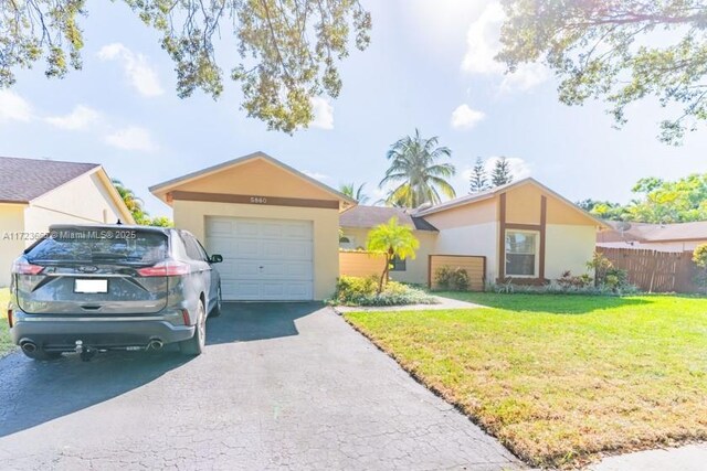 ranch-style home featuring a front lawn and a garage