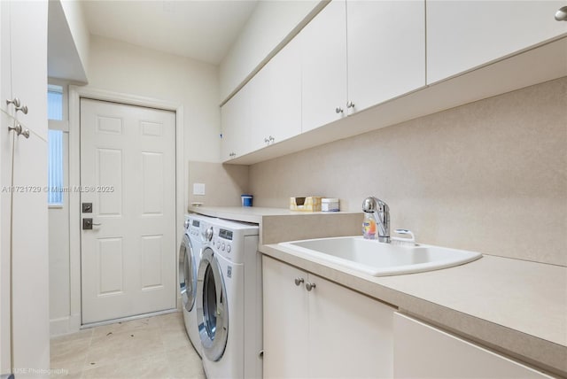 laundry area featuring cabinets, washing machine and dryer, and sink