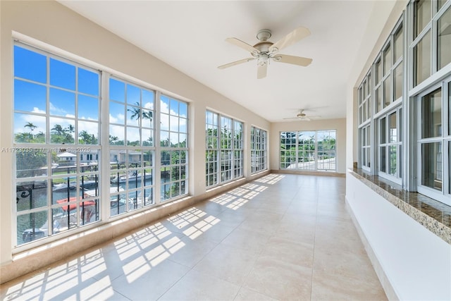 unfurnished sunroom featuring ceiling fan