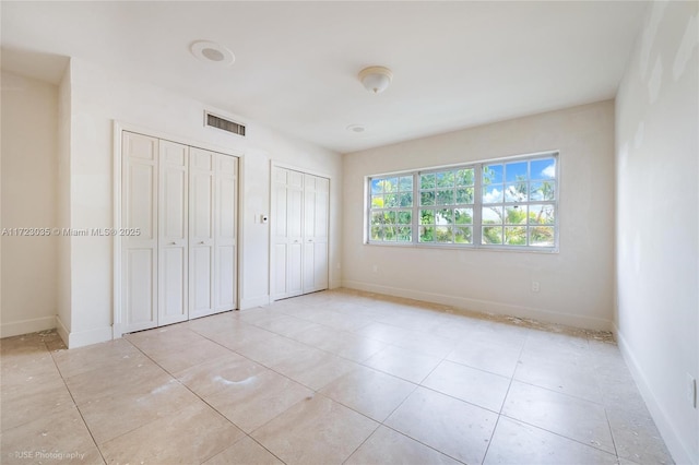 unfurnished bedroom with multiple closets