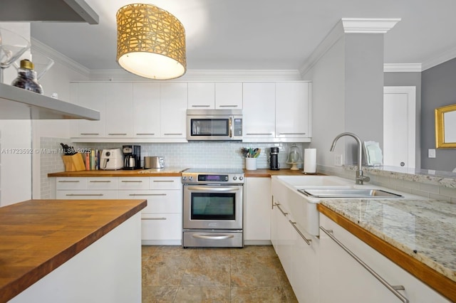 kitchen with crown molding, white cabinets, stainless steel appliances, and wood counters