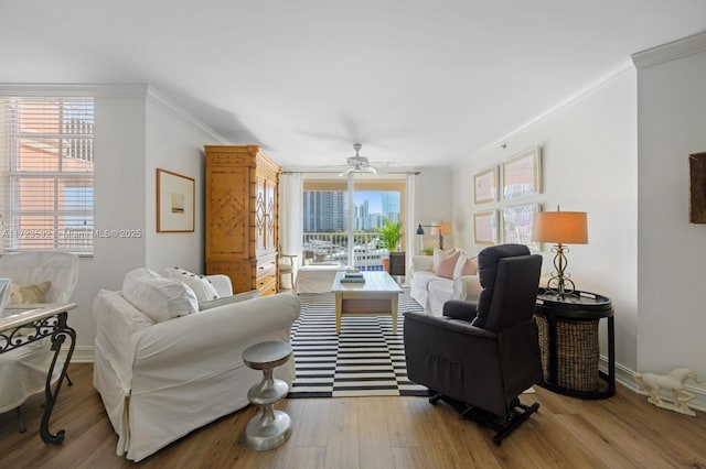 living room featuring ceiling fan, crown molding, and light wood-type flooring