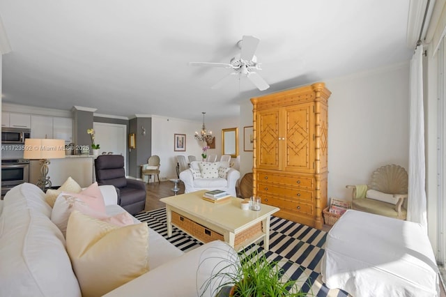 living room featuring hardwood / wood-style floors, ceiling fan with notable chandelier, and ornamental molding