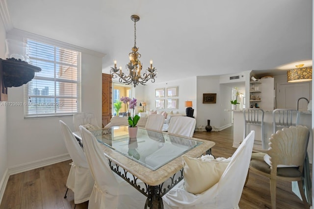 dining space with hardwood / wood-style flooring and an inviting chandelier