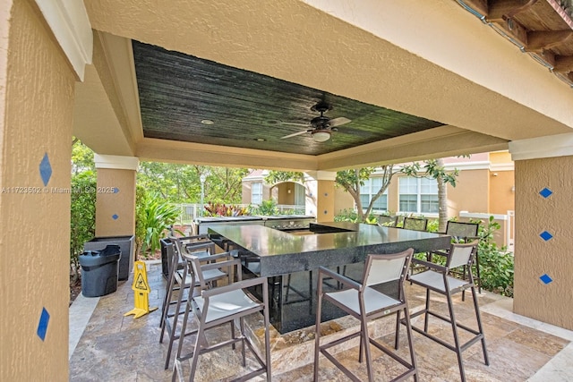 view of patio / terrace featuring ceiling fan and an outdoor bar