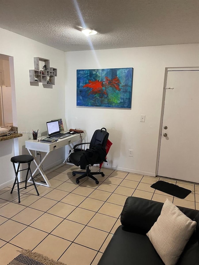 tiled office space featuring a textured ceiling