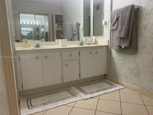 full bathroom with double vanity, wallpapered walls, baseboards, visible vents, and tile patterned floors