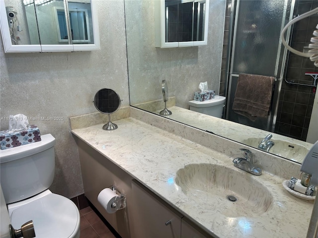 bathroom with toilet, vanity, and tile patterned floors