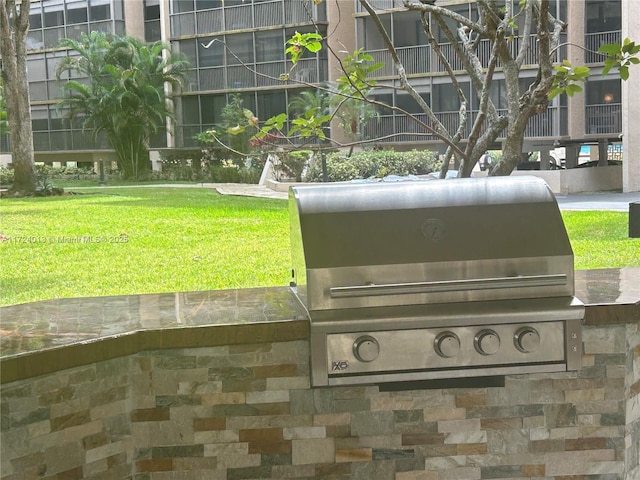 view of home's community with exterior kitchen and a lawn