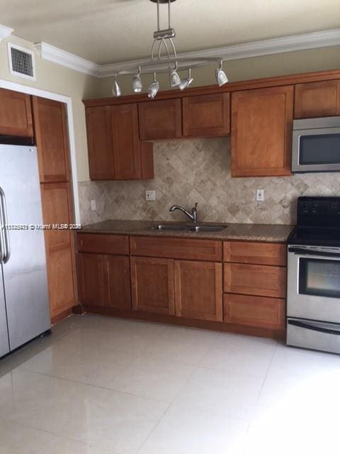 kitchen featuring crown molding, sink, light tile patterned floors, tasteful backsplash, and stainless steel appliances