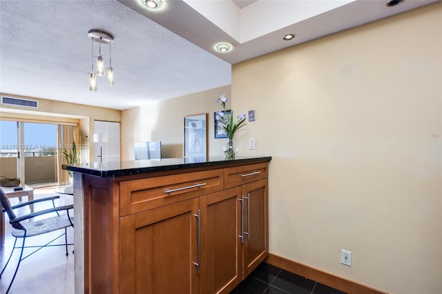 kitchen with pendant lighting, a breakfast bar, kitchen peninsula, and dark tile patterned flooring