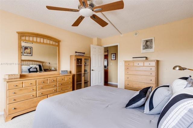 carpeted bedroom with a textured ceiling and ceiling fan