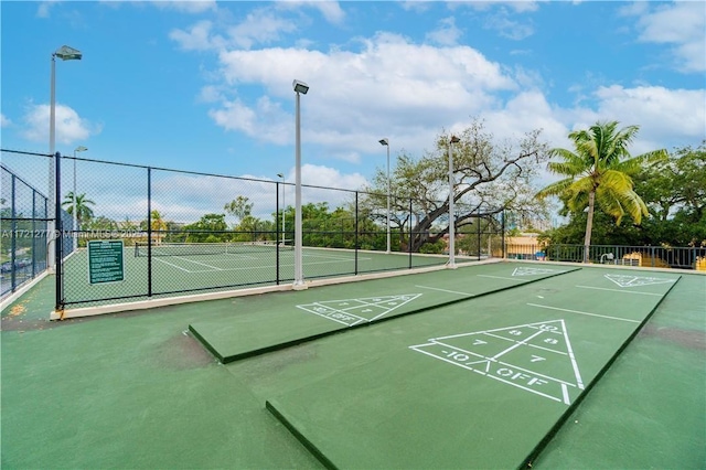 view of home's community with tennis court