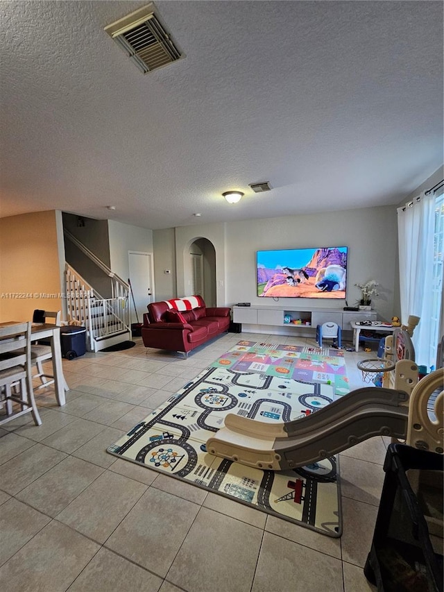 living room featuring a textured ceiling and light tile patterned floors