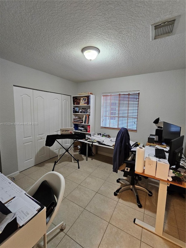 tiled office space with a textured ceiling