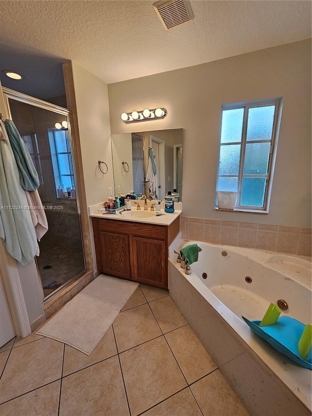 bathroom featuring a textured ceiling, shower with separate bathtub, vanity, and tile patterned flooring