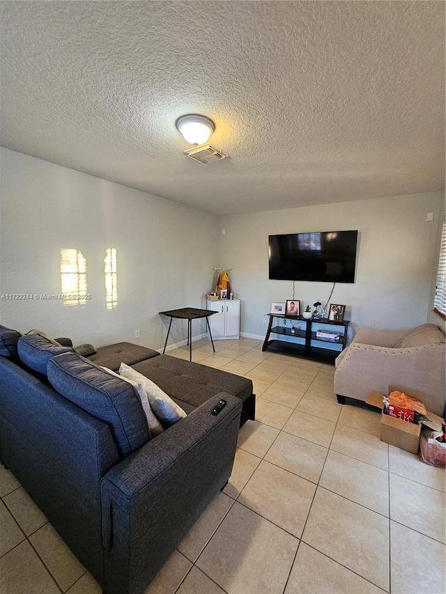 tiled living room featuring a textured ceiling