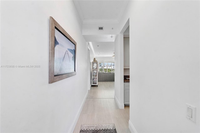 hall featuring light hardwood / wood-style flooring and crown molding