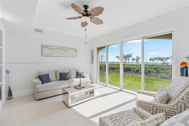 living room with ceiling fan and ornamental molding