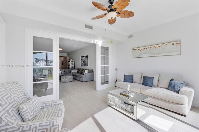 living room with ceiling fan, light hardwood / wood-style floors, and french doors