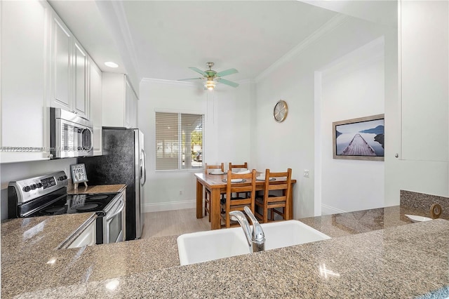 kitchen featuring appliances with stainless steel finishes, crown molding, sink, stone counters, and white cabinetry