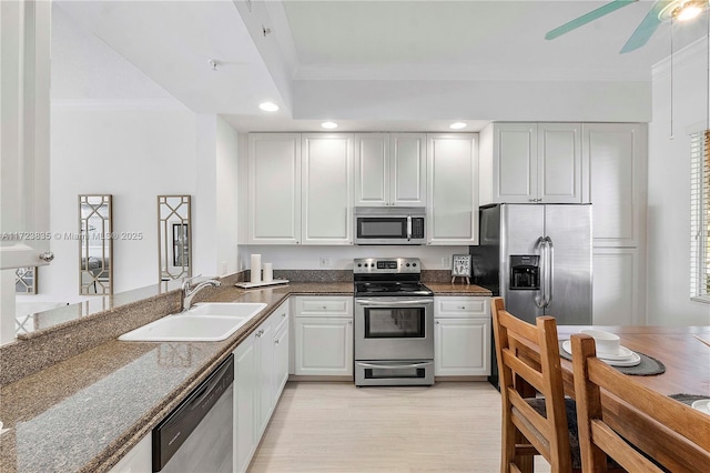 kitchen featuring crown molding, sink, kitchen peninsula, white cabinetry, and stainless steel appliances