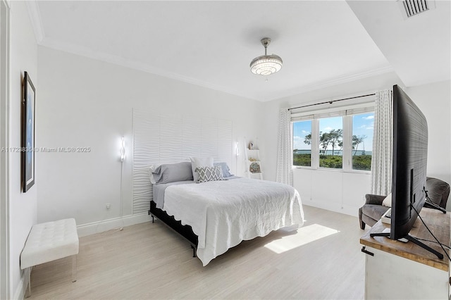 bedroom with crown molding and light wood-type flooring