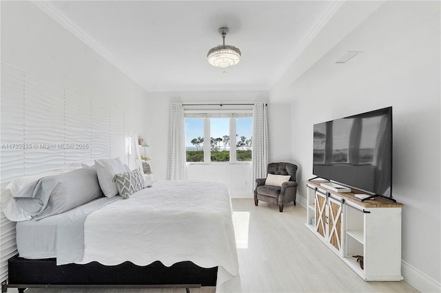 bedroom featuring light wood-type flooring and crown molding