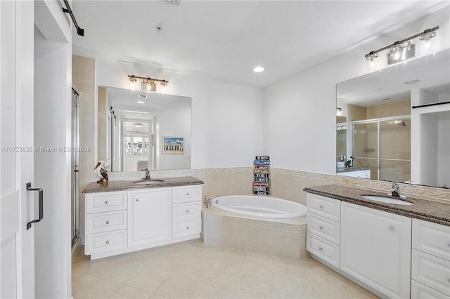 bathroom with tile patterned floors, vanity, independent shower and bath, and a textured ceiling