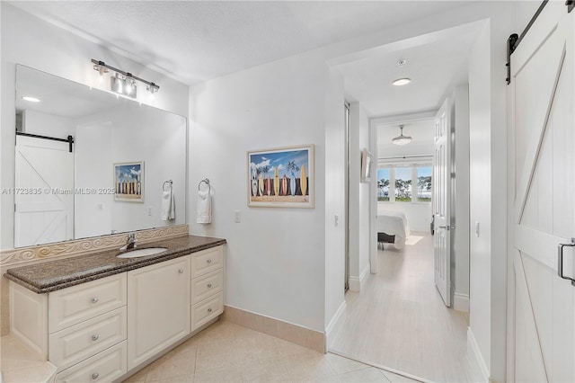 bathroom with tile patterned flooring, vanity, and a textured ceiling