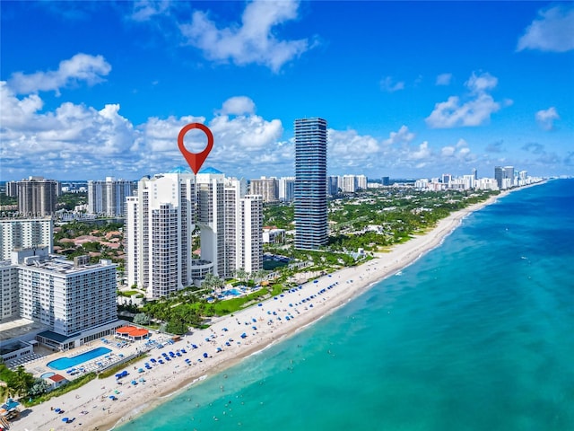 drone / aerial view featuring a water view and a view of the beach