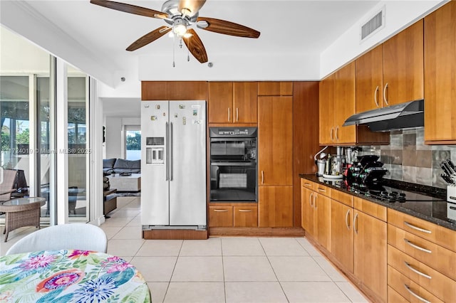 kitchen with black appliances, dark stone counters, decorative backsplash, ceiling fan, and light tile patterned floors