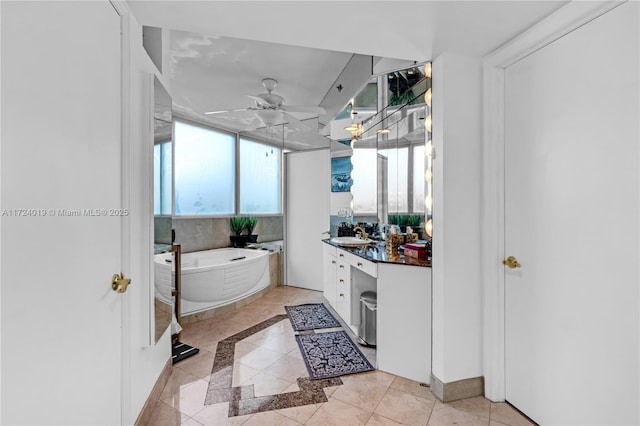 bathroom featuring ceiling fan, vanity, tile patterned floors, and a bathing tub